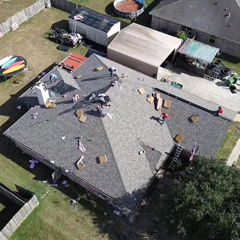 Asphalt shingle roof replacement with workers and materials