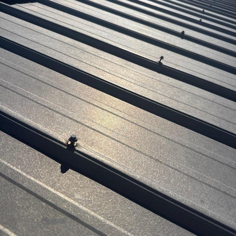 Metal roofing panels with hail damage and fasteners