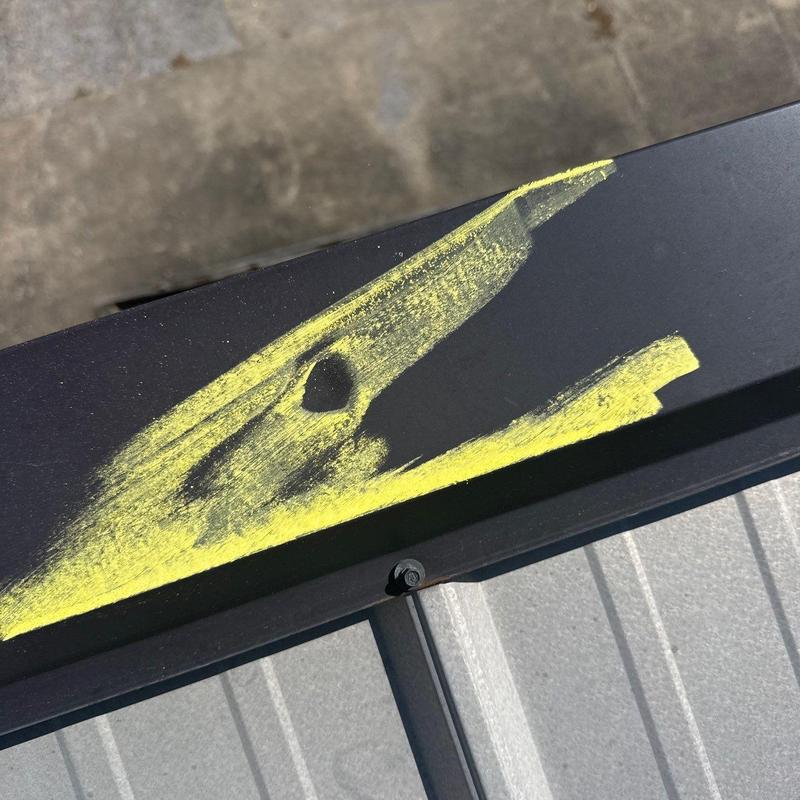 Roof metal flashing with hail damage marked in yellow