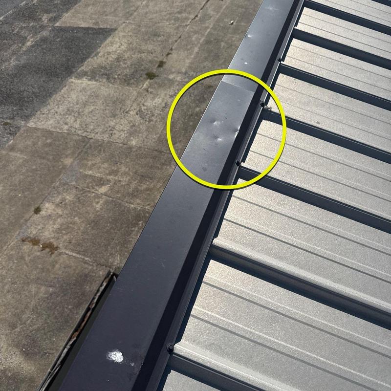 Metal roof flashing with hail damage dents