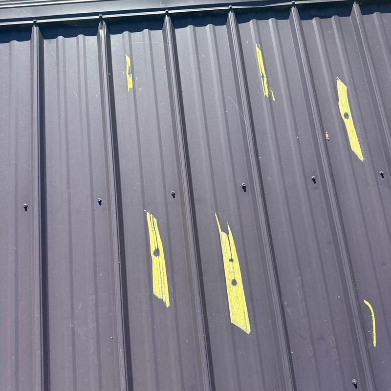 Metal roofing panels with hail damage markings