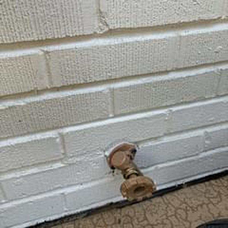 Hose bib valve on exterior brick wall installation