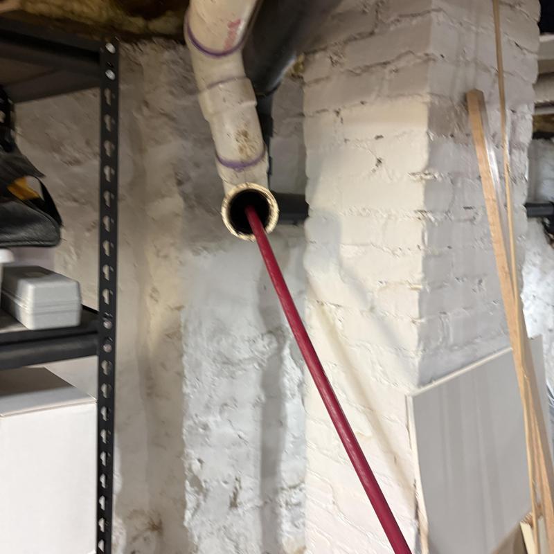 PVC drain pipe hydro-jet cleaning with red hose in basement PVC drain pipe hydro-jet cleaning with red hose in basement