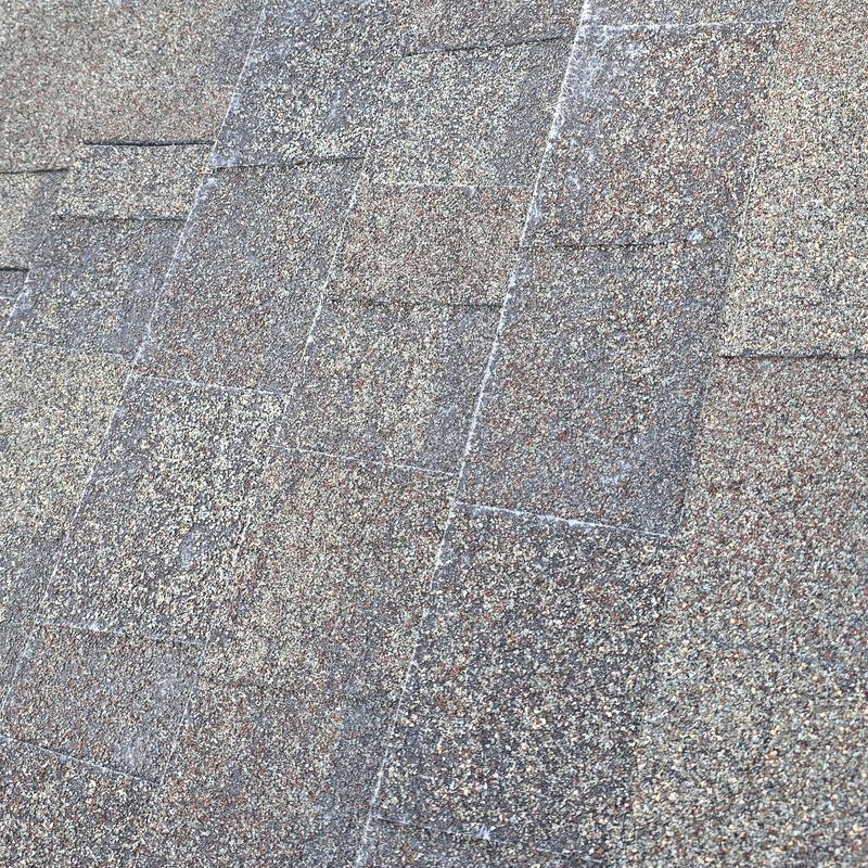Roof shingles with visible hail damage surface dents