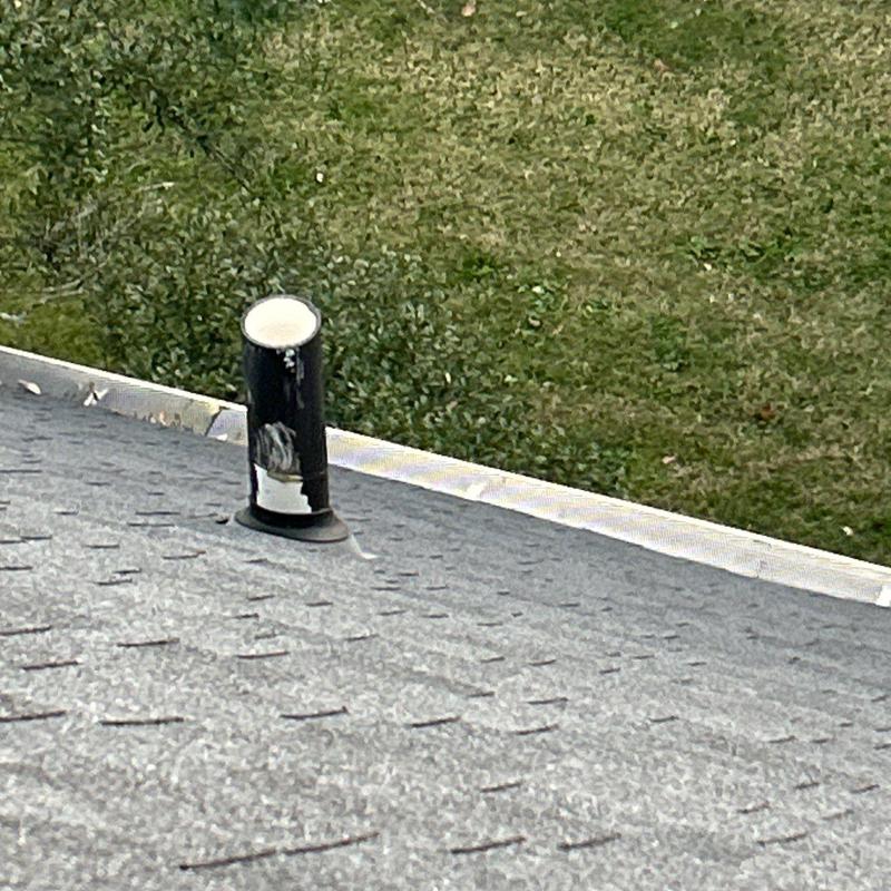 Roof vent pipe with damaged flashing on asphalt shingles