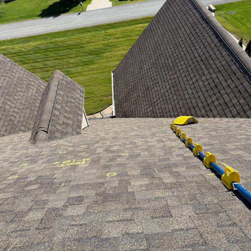 Asphalt shingles with hail damage markings on roof