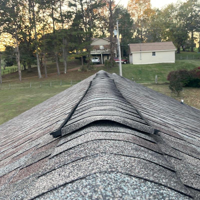 Ridge cap shingles and flashing on roof ridge