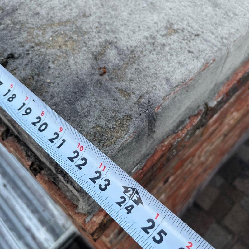 Mortar joint damage on brick chimney with measuring tape