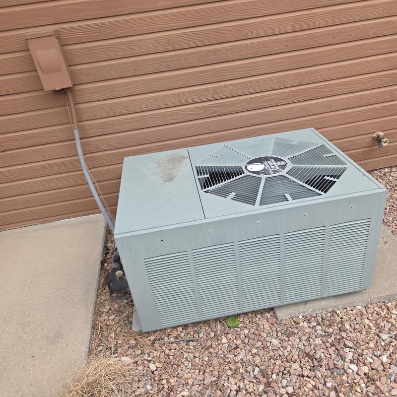 Furnace outdoor condensing unit by house wall
