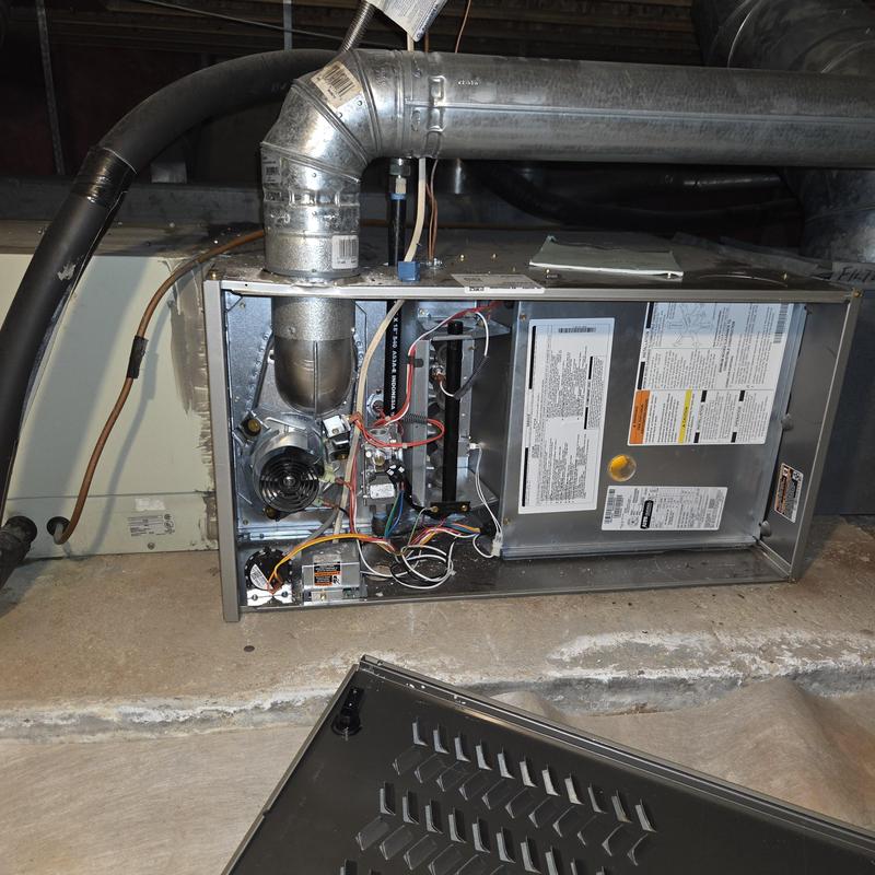 Furnace interior with wiring and ventilation pipe exposed