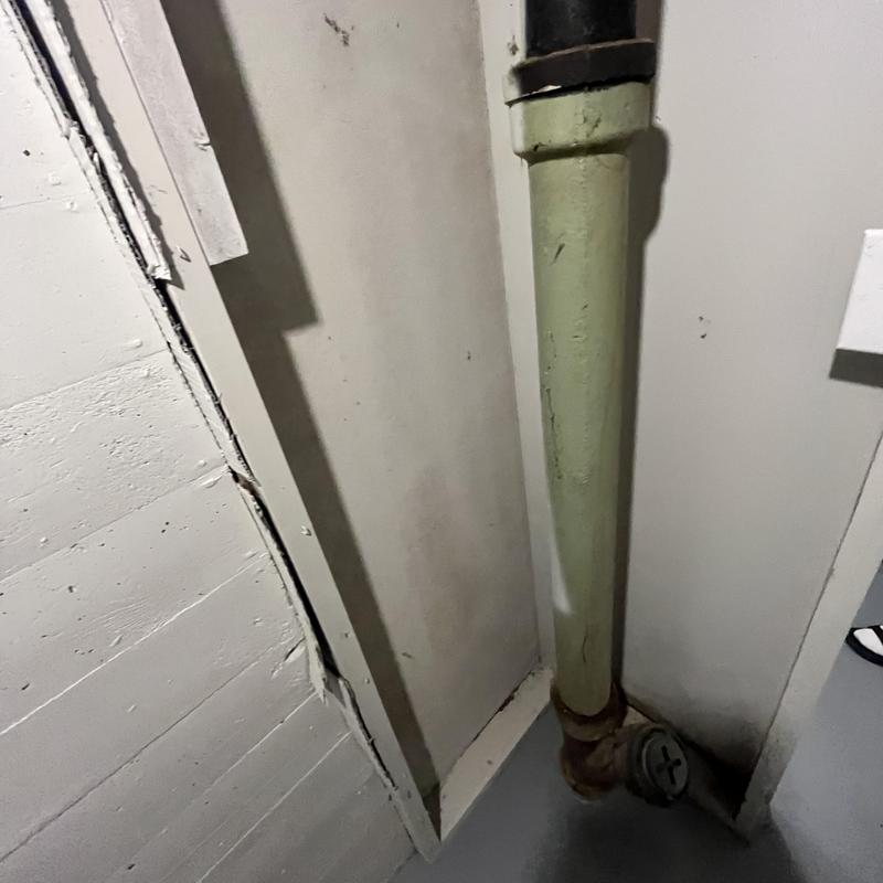Cast iron drain stack in basement corner