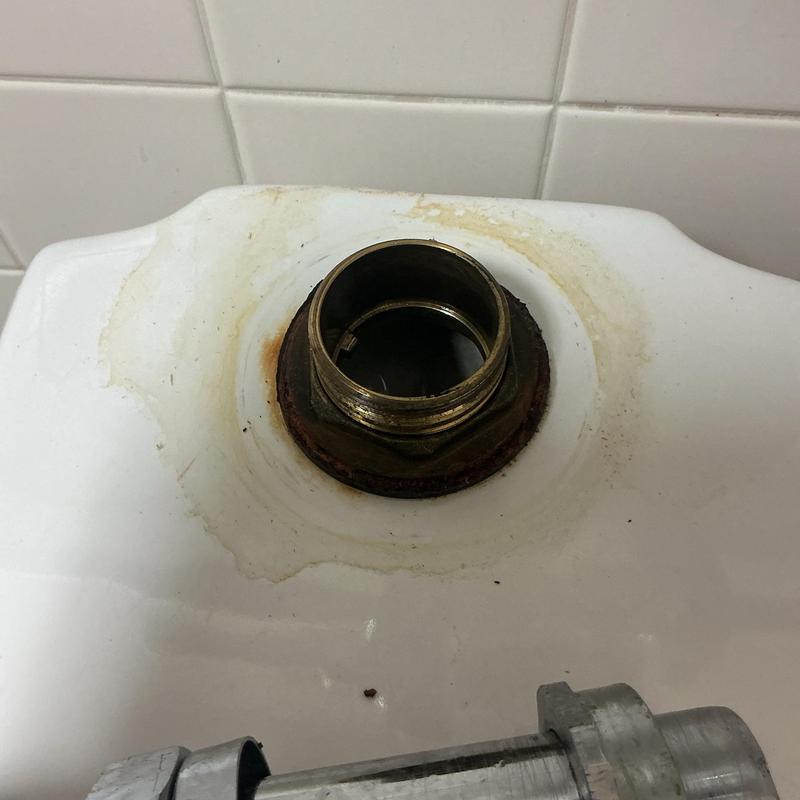Flushometer valve inlet on stained commercial toilet tank Flushometer valve inlet on stained commercial toilet tank
