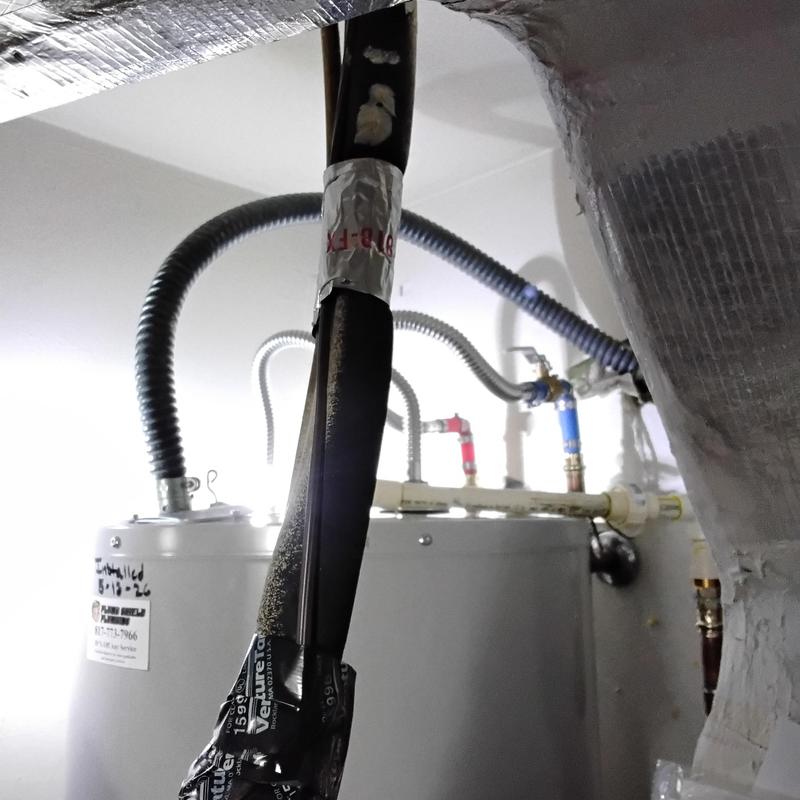 Electric water heater with insulated pipes in hallway