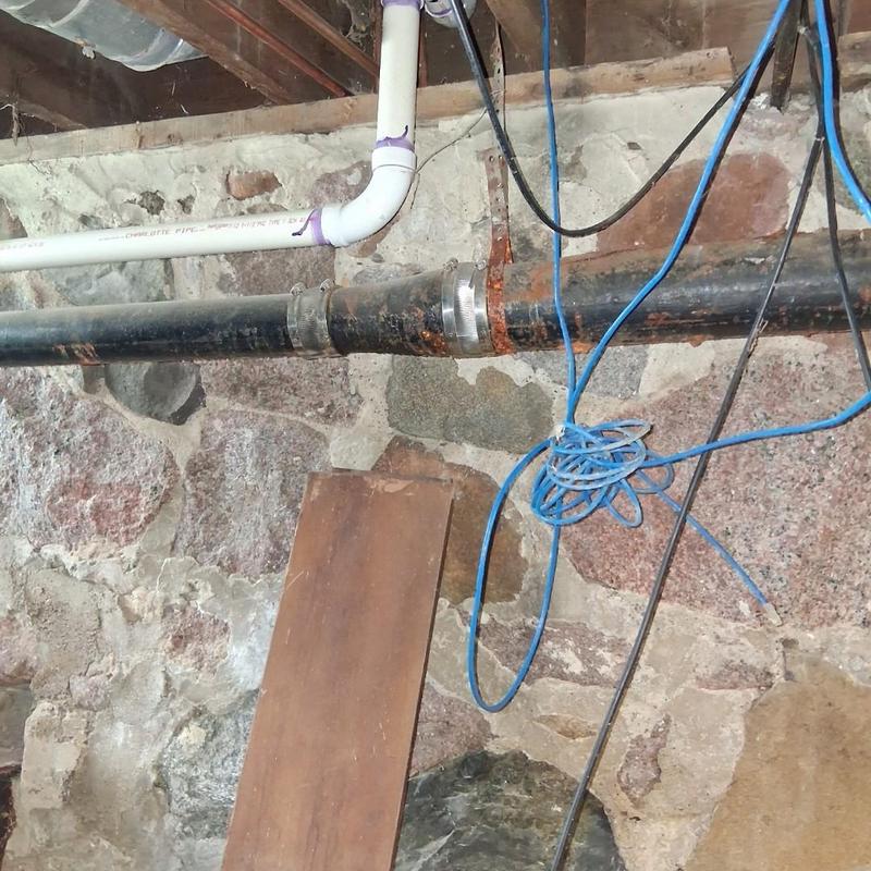 Cast iron drain pipe with repair estimate in basement