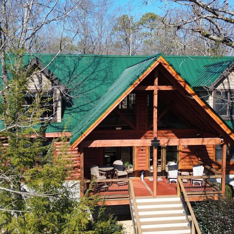 Green metal roofing system on custom log cabin