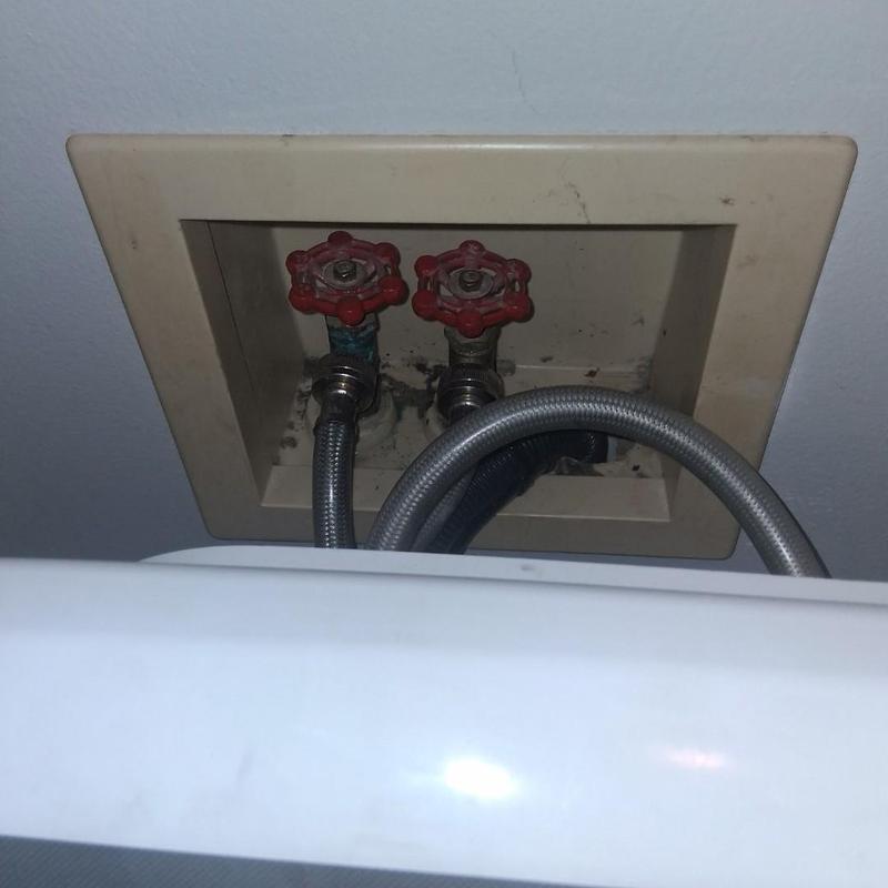 Washer box with red bibb valves and hoses