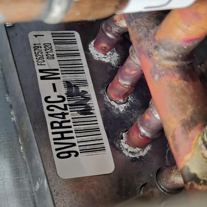 HVAC coil data plate with copper piping and corrosion