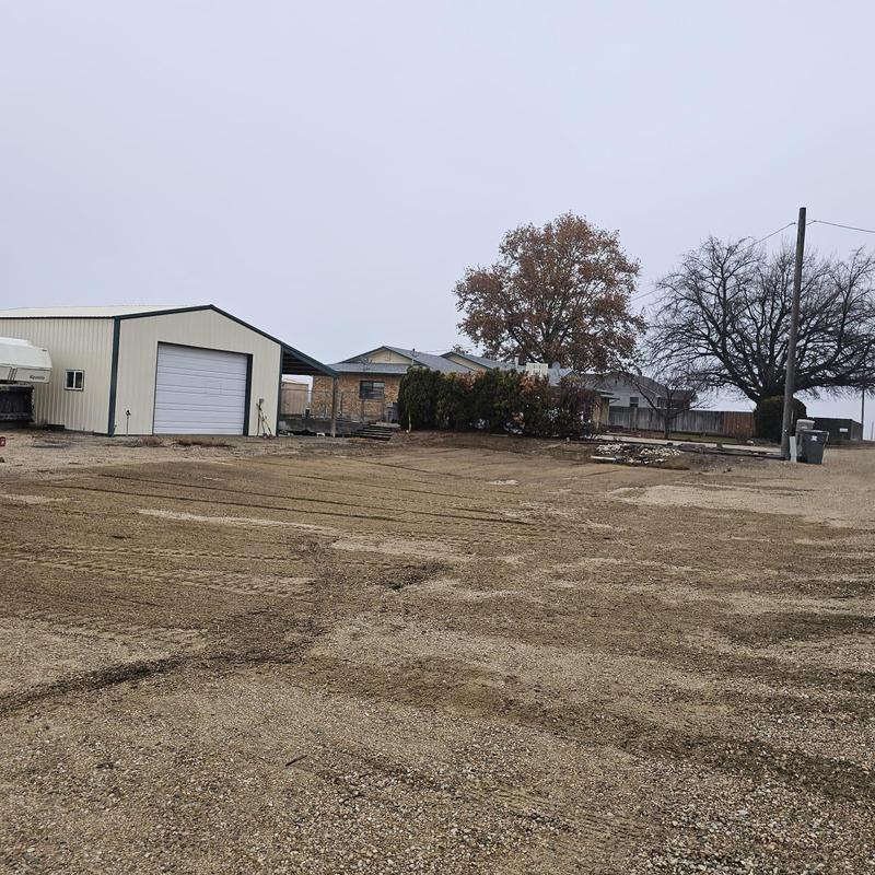 Gravel driveway with garage and trees in overcast weather