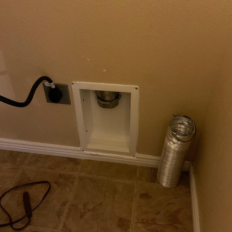 Dryer vent box with detached vent hose on tile floor Dryer vent box with detached vent hose on tile floor