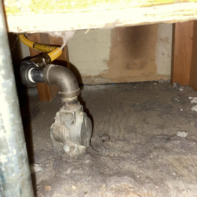 Gas line valve with yellow flex tubing under cabinet Gas line valve with yellow flex tubing under cabinet