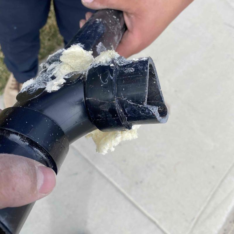 Broken black plastic waste pipe with insulation residue Broken black plastic waste pipe with insulation residue