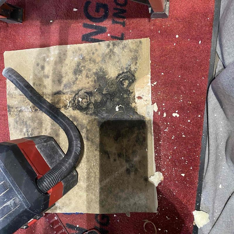 Water damage on sheetrock panel with debris nearby Water damage on sheetrock panel with debris nearby