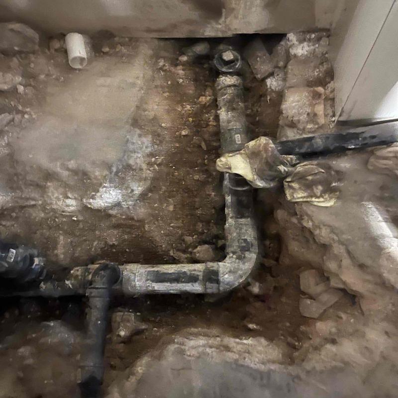 Basement sewer pipe with grease blockage and gloves
