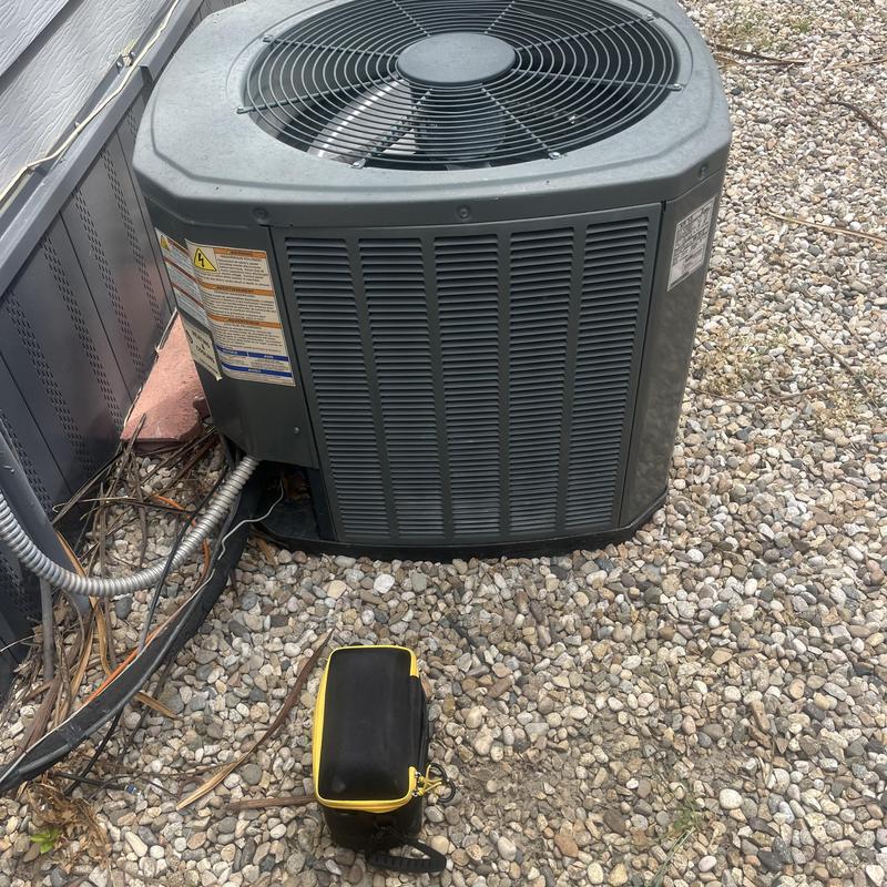 Central air conditioner unit with technician tool bag nearby Central air conditioner unit with technician tool bag nearby