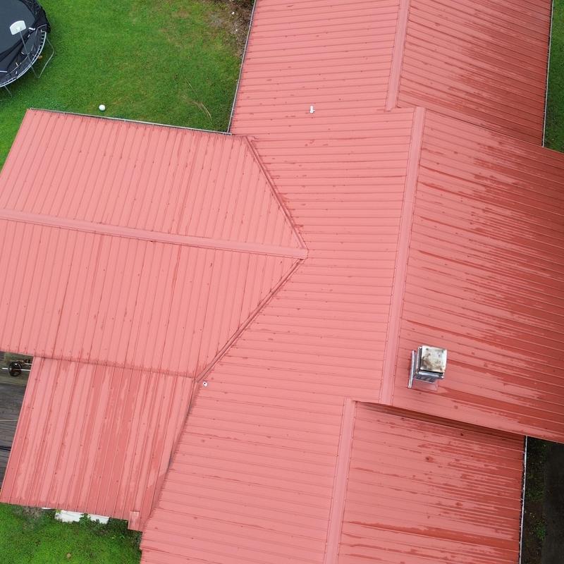 Red metal roof with clean panel installation and ridges