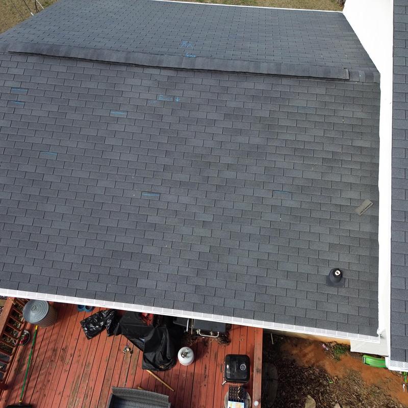 New dark asphalt shingle roof with ridge vent installed