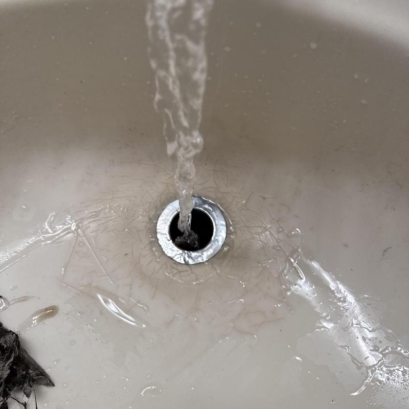 Basin drain with running water after clearing blockage Basin drain with running water after clearing blockage