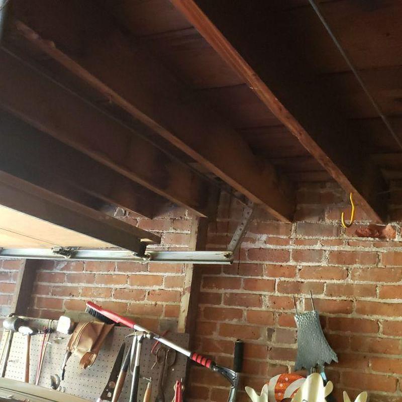 Garage ceiling joists and brick wall with hanging tools Garage ceiling joists and brick wall with hanging tools