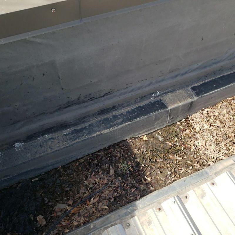Gutter and wall joint with leaves and debris buildup