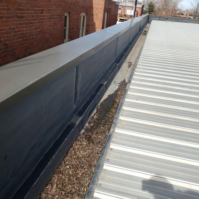 Metal roof gutter with leaves and debris buildup