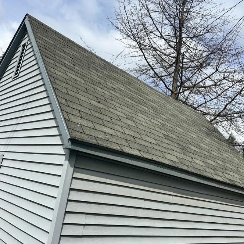 Garage roof with worn shingles and siding panels Garage roof with worn shingles and siding panels