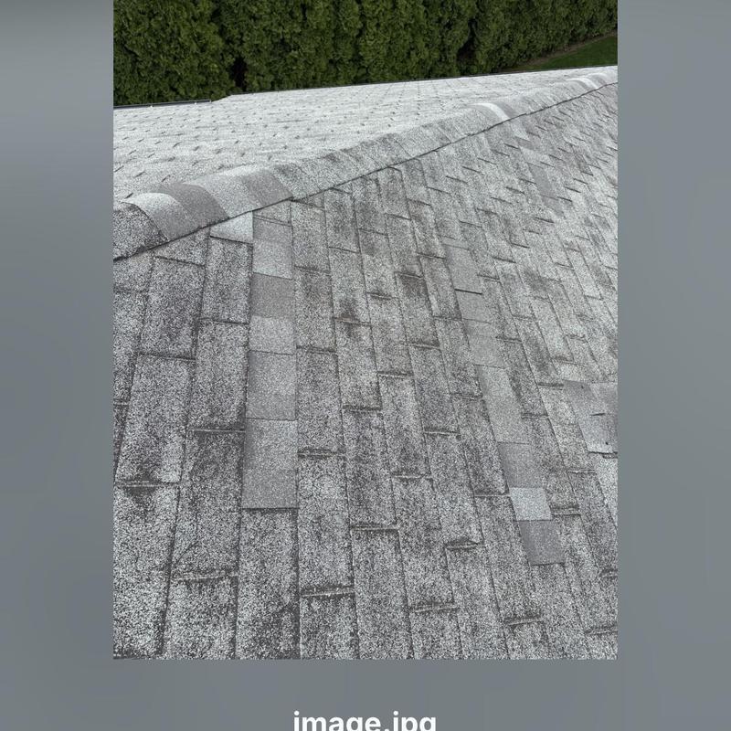 Asphalt shingles and ridge shingles on roof missing sections