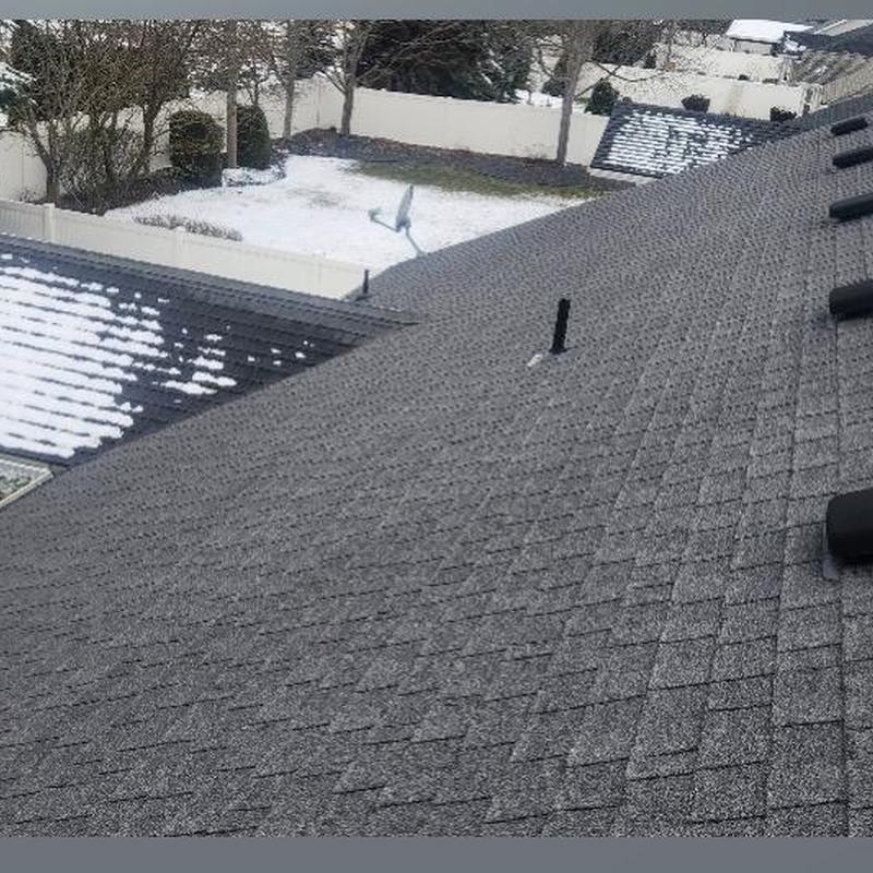 Asphalt shingle roof with snow patches during inspection Asphalt shingle roof with snow patches during inspection