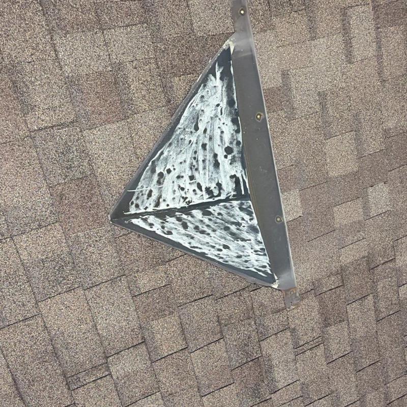 Roof valley flashing with storm damage on asphalt shingles