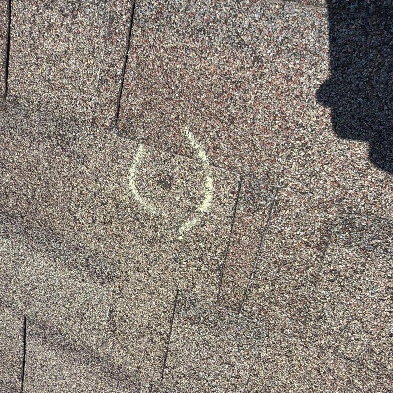 Asphalt shingle roof with hail damage marked in chalk