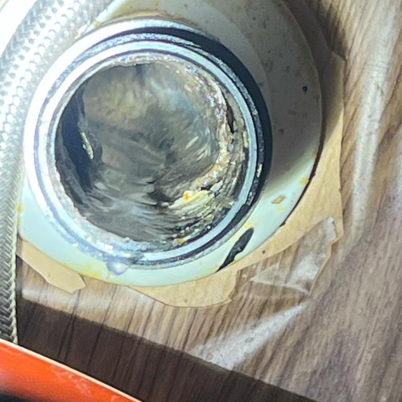 Kitchen sink drain line viewed through cleanout opening