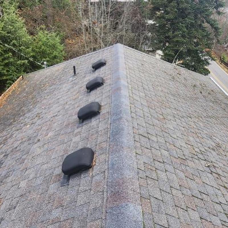 Asphalt shingle roof with vent covers and ridge cap Asphalt shingle roof with vent covers and ridge cap