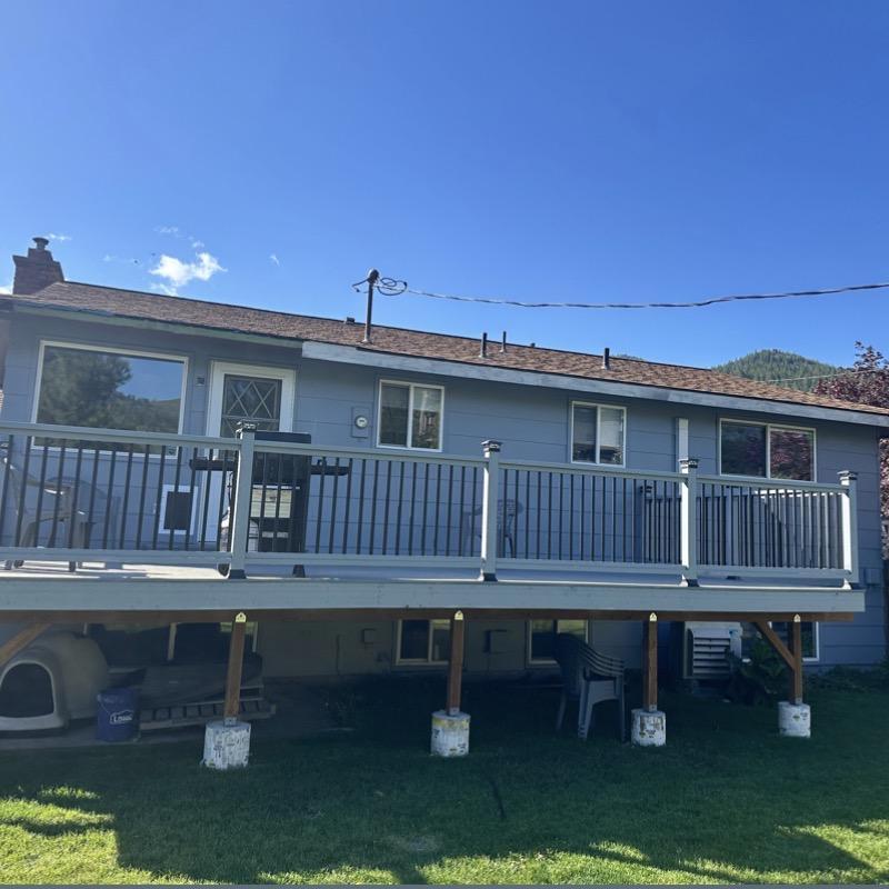 Deck railing replacement on blue house exterior Deck railing replacement on blue house exterior
