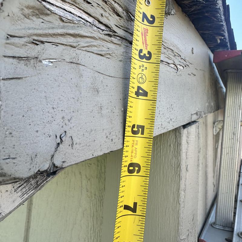 Damaged fascia board with measuring tape Damaged fascia board with measuring tape