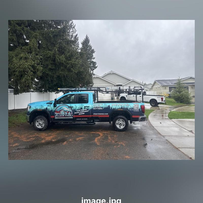 Gutter installation truck parked outside homes on rainy day Gutter installation truck parked outside homes on rainy day