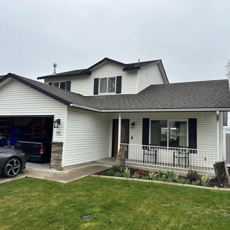 Asphalt shingle roof on residential home with porch Asphalt shingle roof on residential home with porch