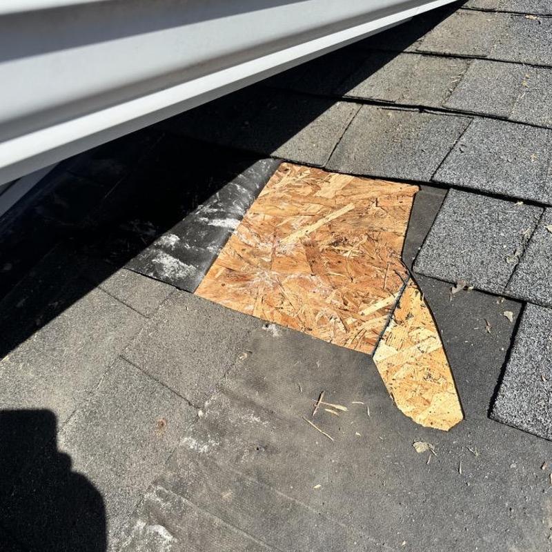 Roof decking patch under asphalt shingles near gutter