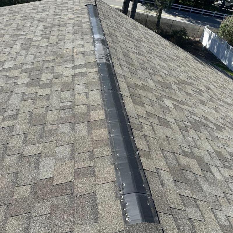 Ridge shingle replacement on asphalt roof ridge