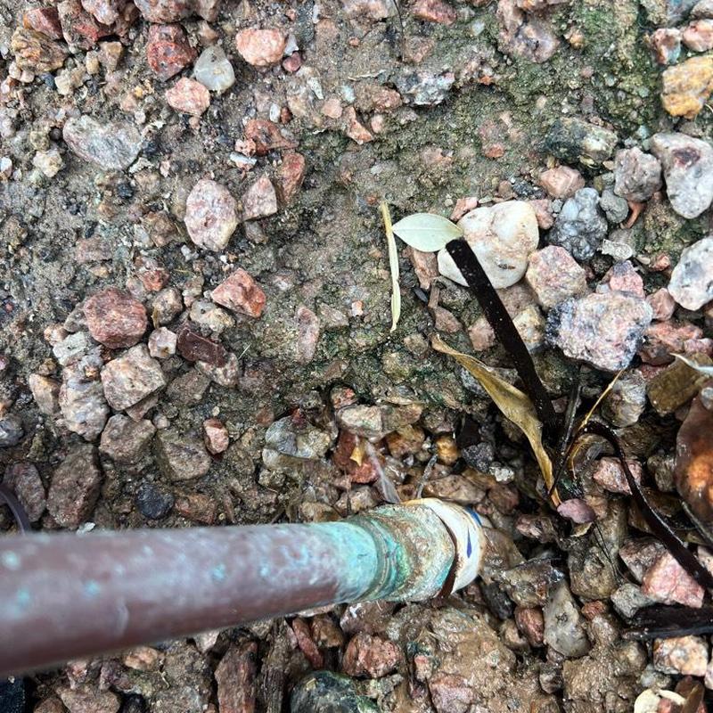 Copper pipe and landscaping PVC connection leak repair site