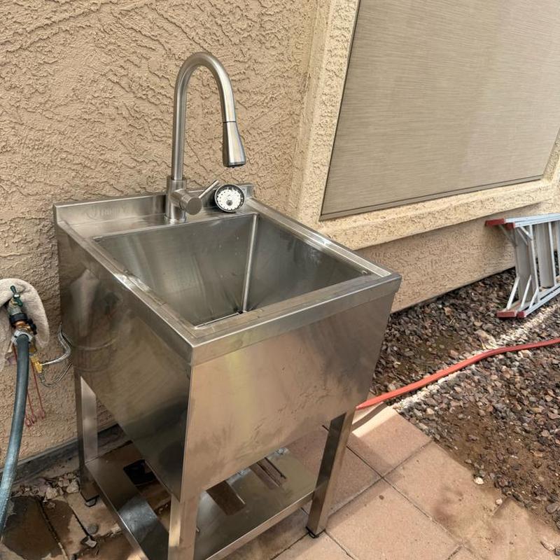 Utility sink installation with faucet in backyard