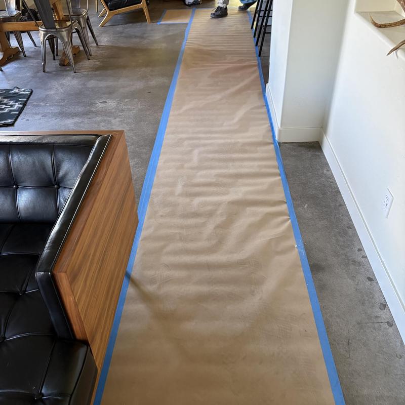 Floor protection paper taped along hallway floor edge Floor protection paper taped along hallway floor edge
